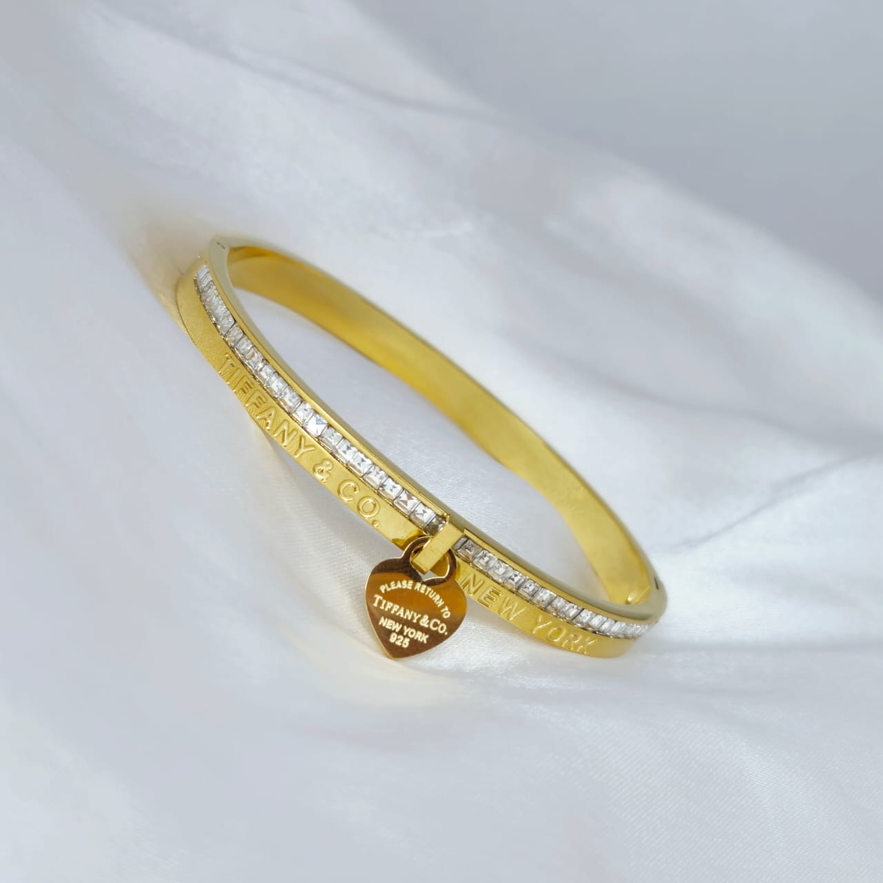 Gold bracelet with diamond accents on a white background