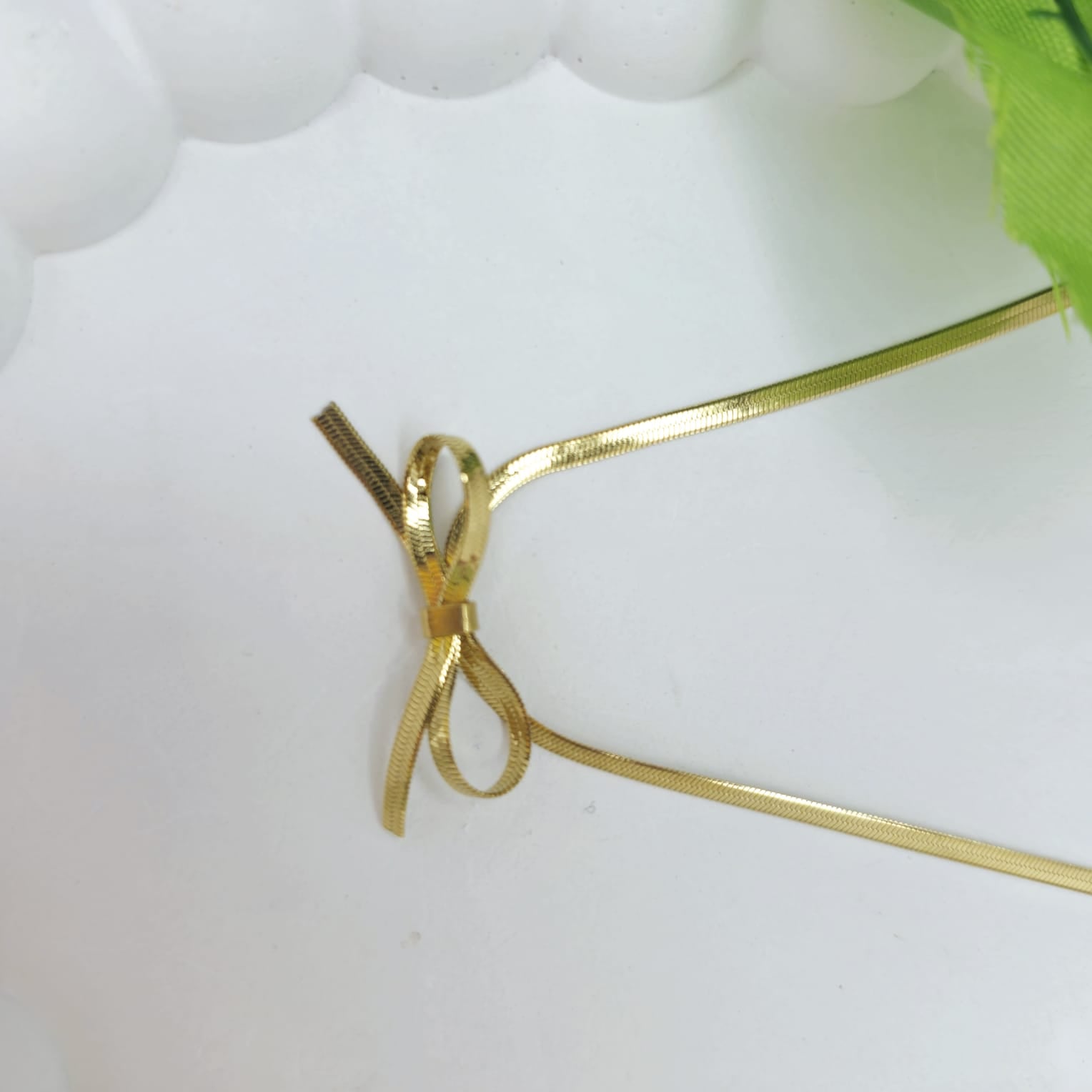 Gold bow-shaped hair clip on a white background